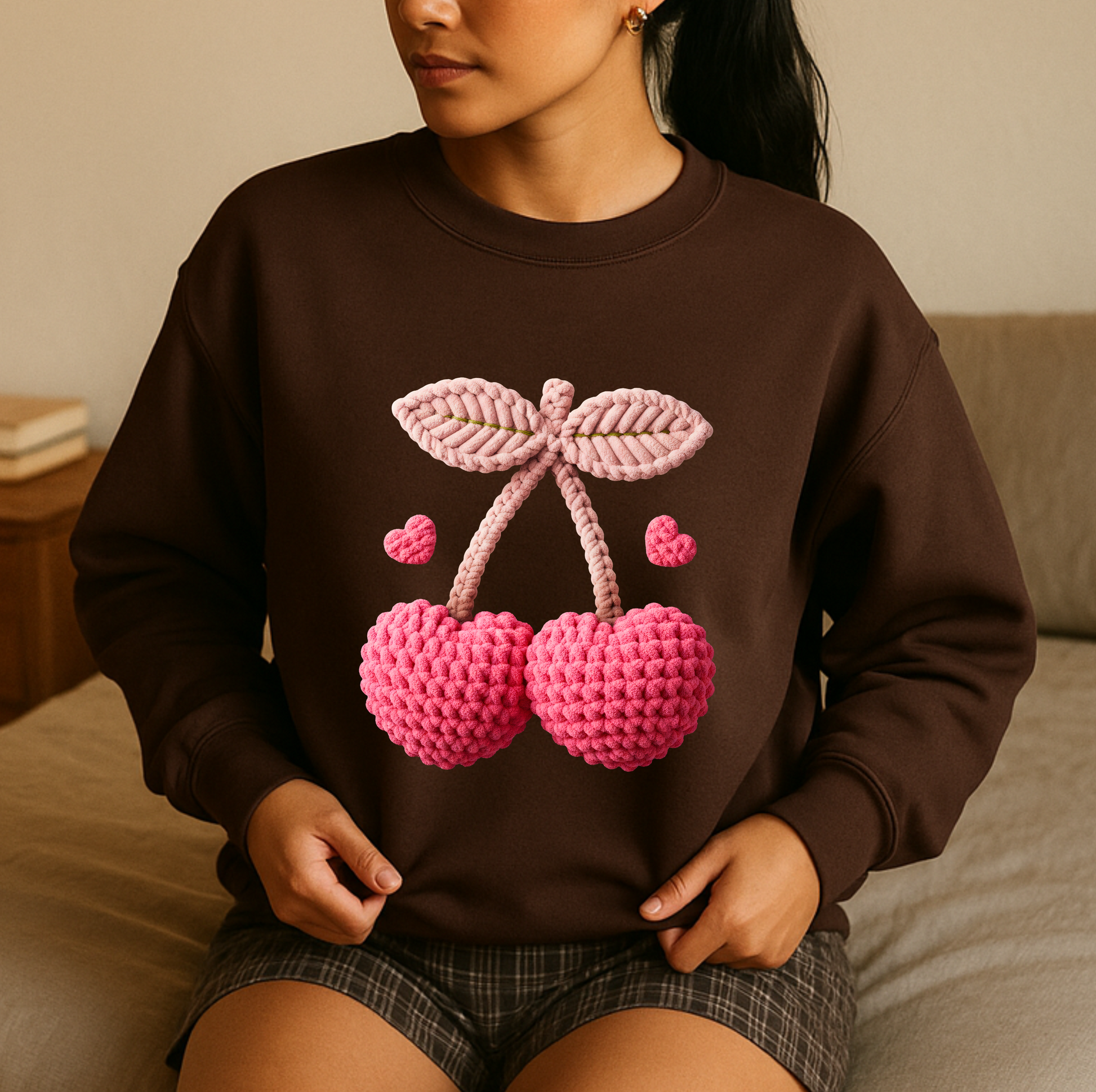 Person wearing a brown sweatshirt with pink cherry design